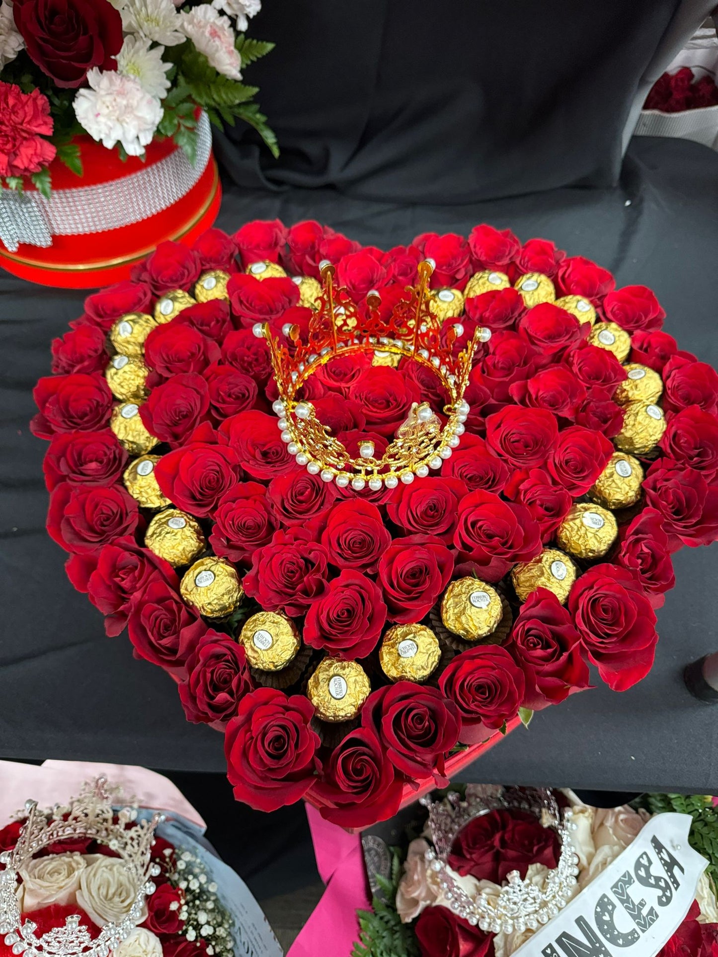 Caja de rosas rosas recién cortadas en forma de corazón con bombones